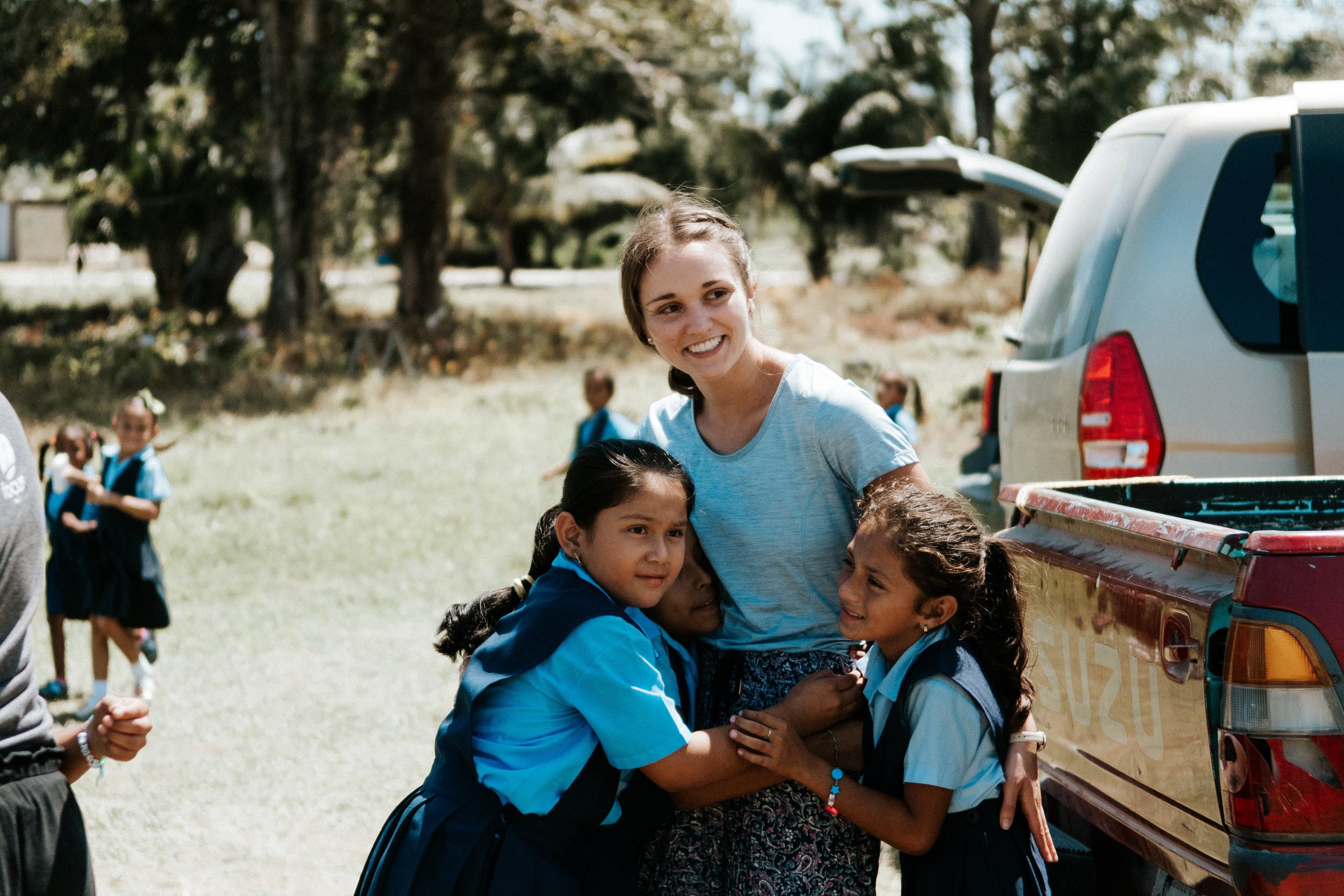 Women hugging two children.